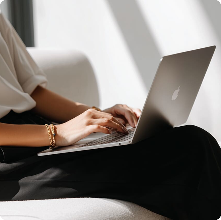 Laptop showing a fashion Shopify storefront on a dark pedestal