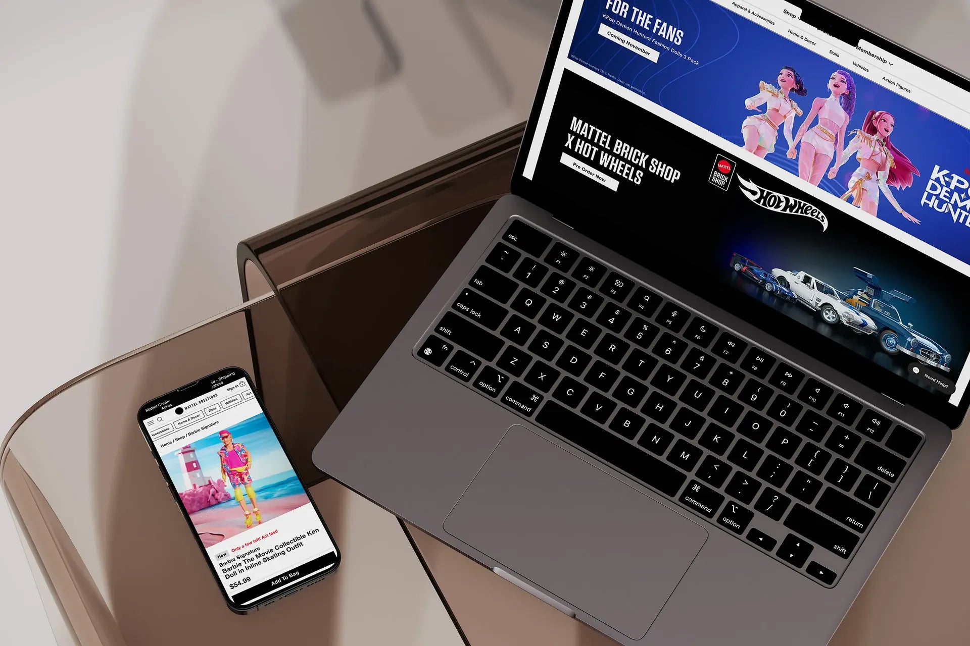 Laptop and phone showing an ecommerce storefront on a glass table