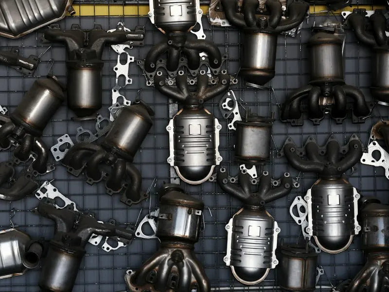 Catalytic converters and exhaust headers displayed on a workshop wall